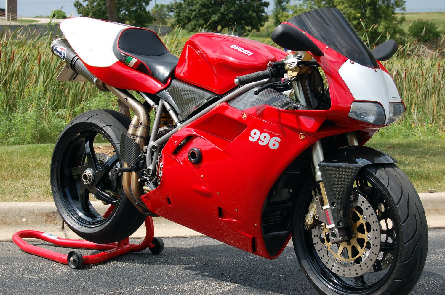 Red and white Ducati 996 sportbike parked on a stand