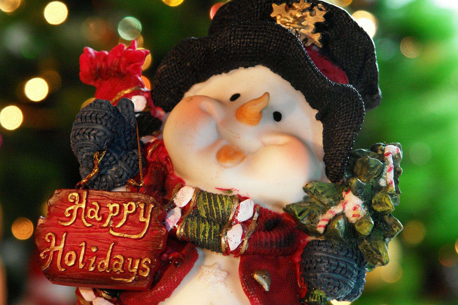 A close-up of a cheerful snowman figurine holding a 