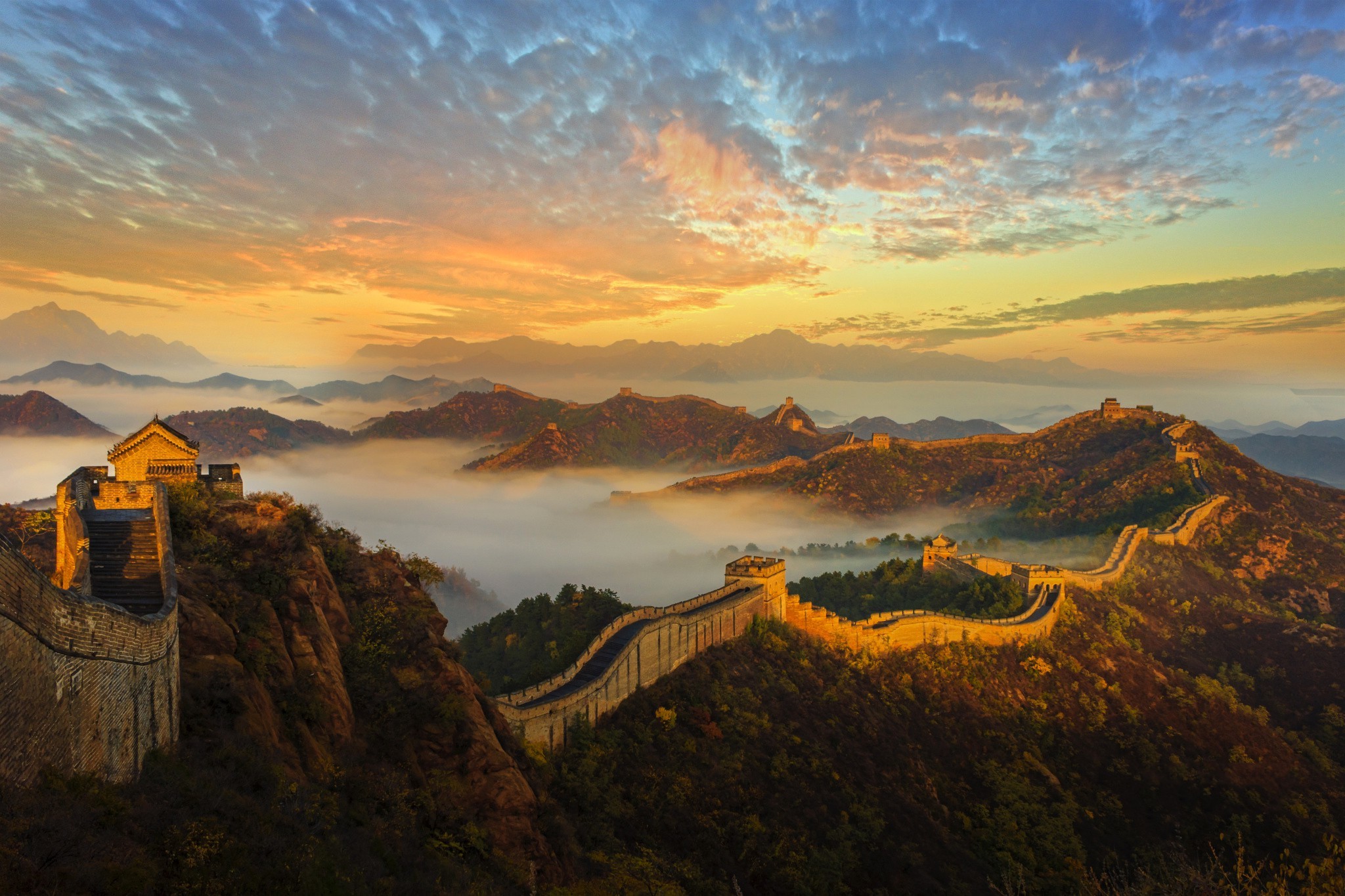 Sunrise over the Great Wall of China, a breathtaking view of ancient architecture amidst a mountainous landscape