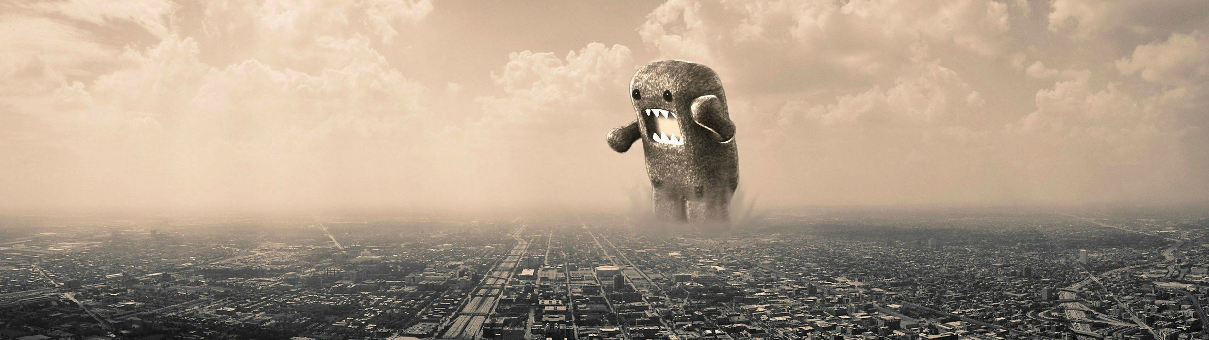 A giant Domo-kun plushie looms over a sprawling cityscape in a sepia-toned, apocalyptic scene, perfect for a dual-monitor 4k wallpaper