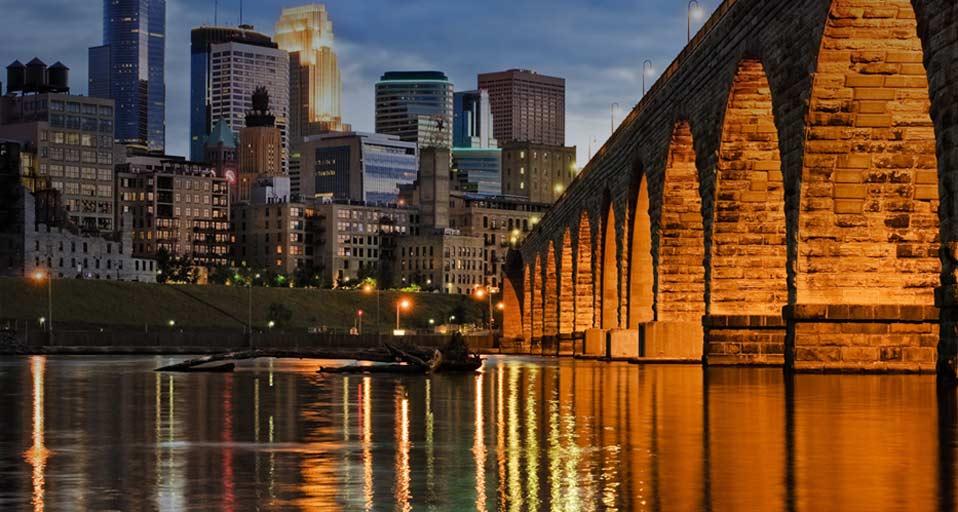 Minneapolis Skyline And Stone Arch Bridge Over The Mississippi River