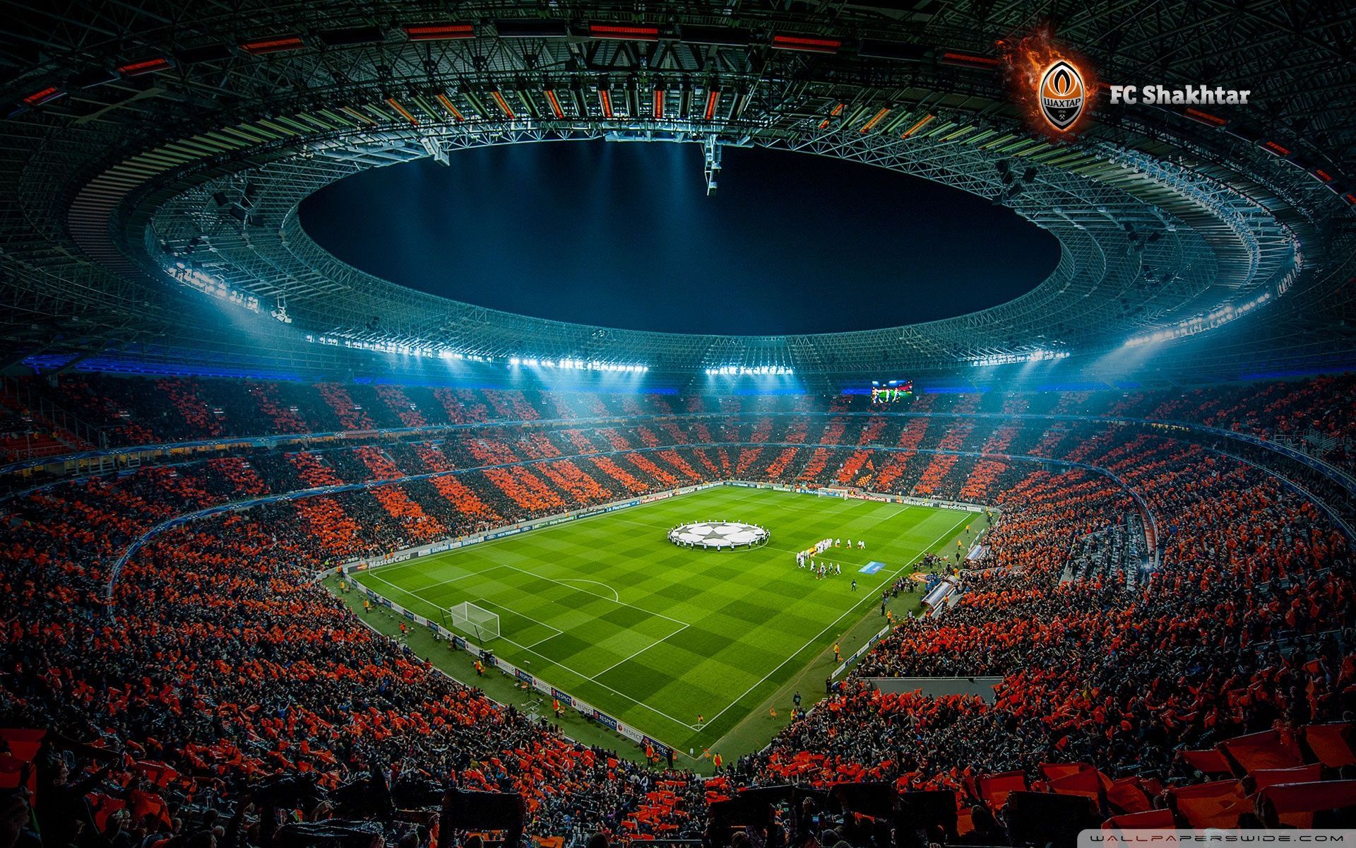 A vibrant soccer stadium filled with cheering fans during a night match