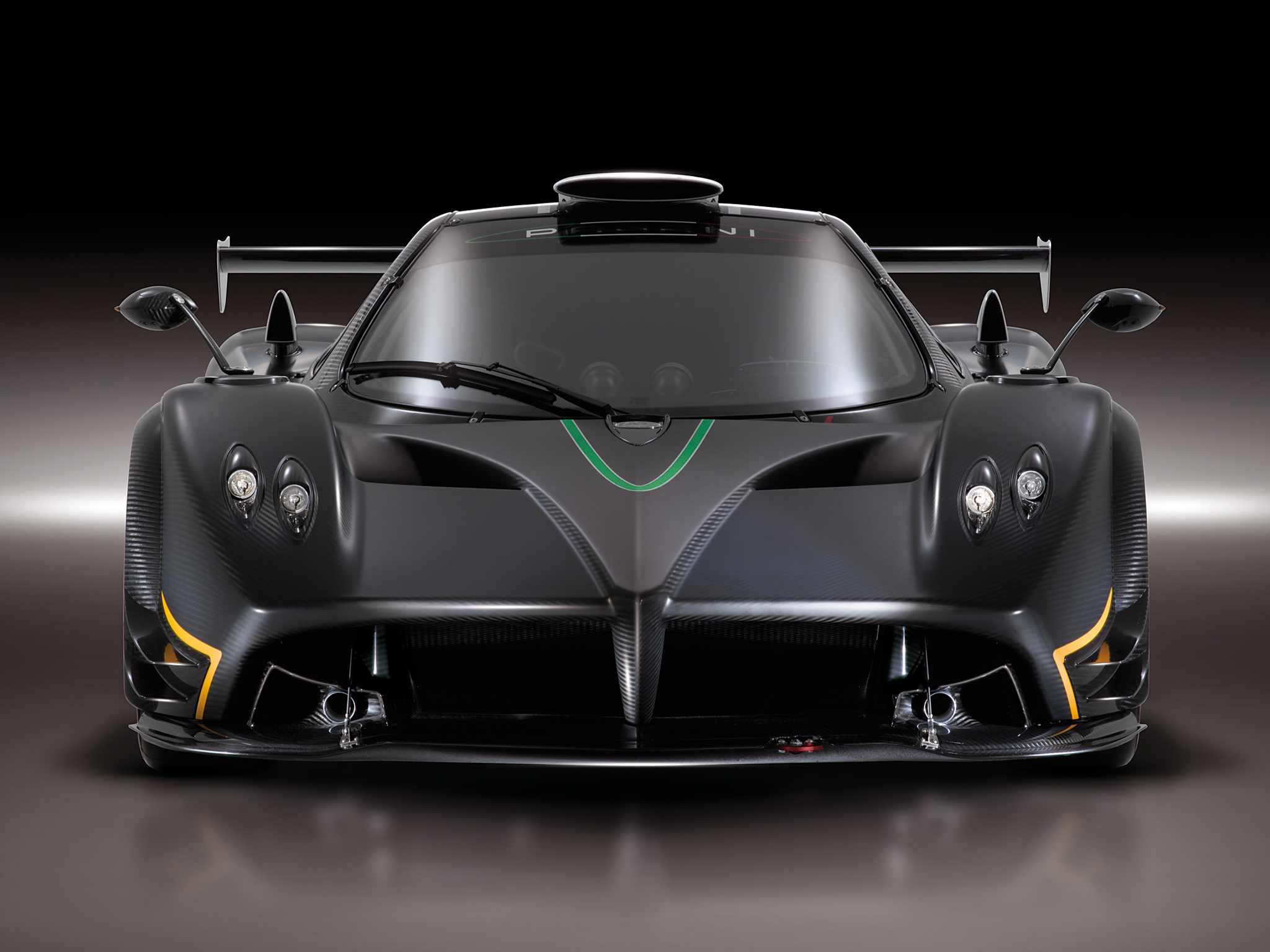 A front view of a sleek black Pagani Huayra, highlighting its carbon fiber body and aerodynamic design