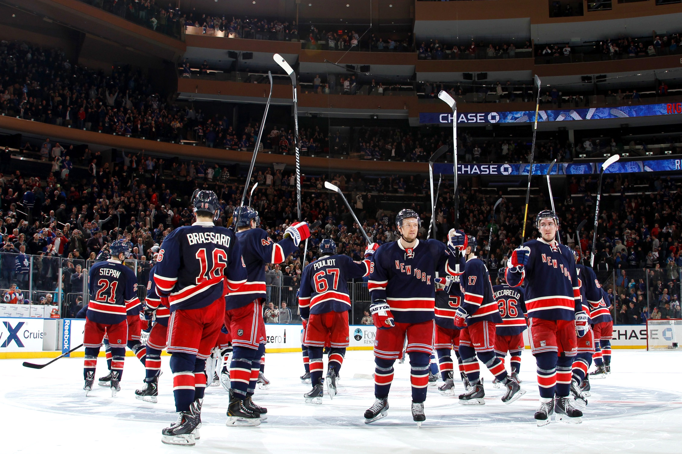 New York Rangers players celebrating on the ice after a victory at Madison Square Garden