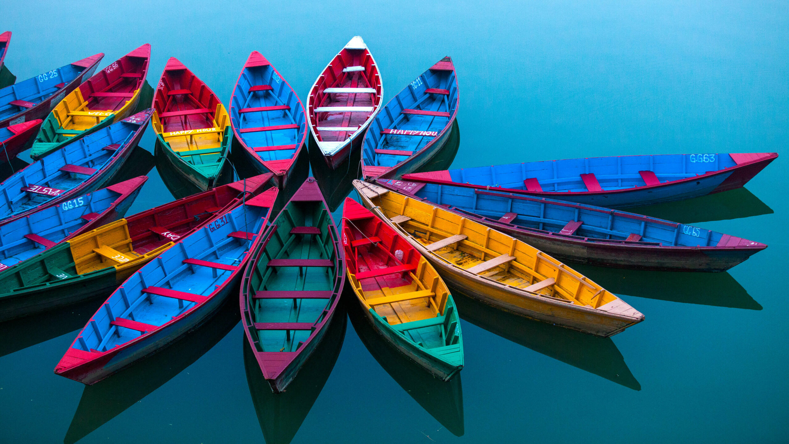 Colorful boats arranged in a circle on a vibrant blue lake