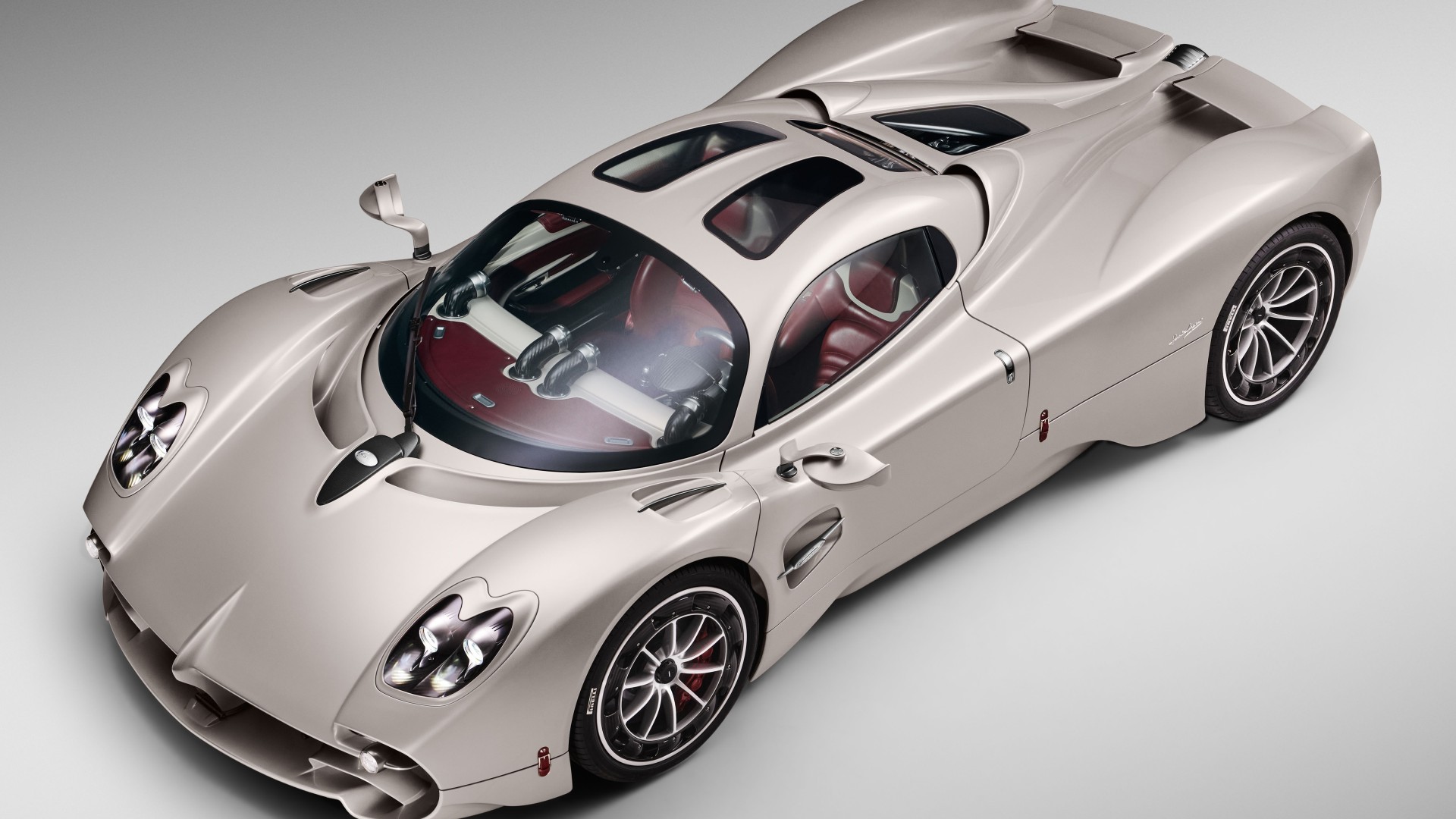 A high-angle, studio shot of a silver Pagani Huayra, showcasing its sleek design and intricate details