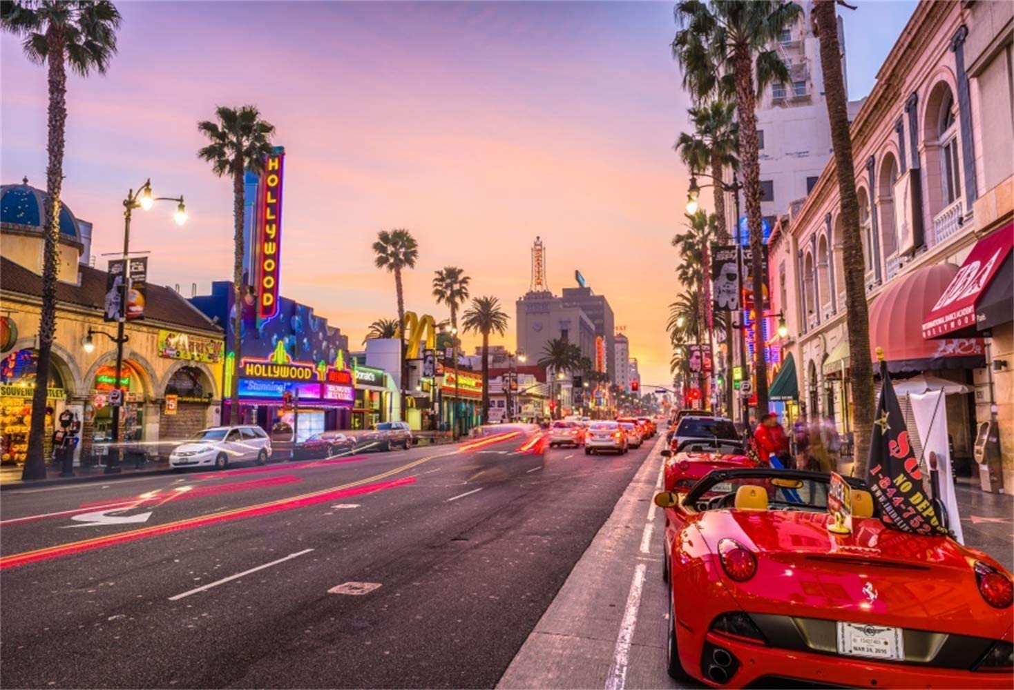 A vibrant sunset over Hollywood Boulevard, showcasing the iconic Hollywood sign and bustling street life
