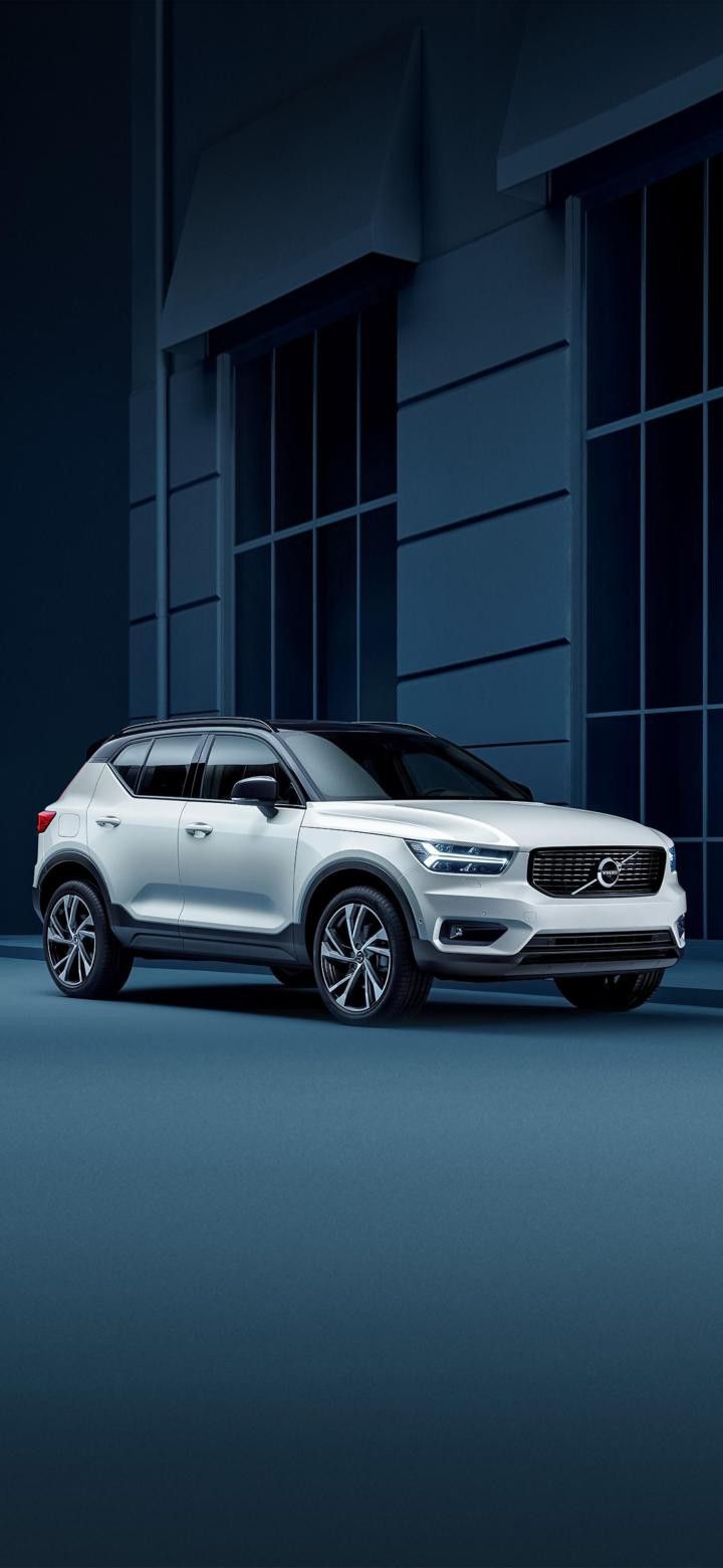 White Volvo Suv Parked In Front Of A Building Wallpaper
