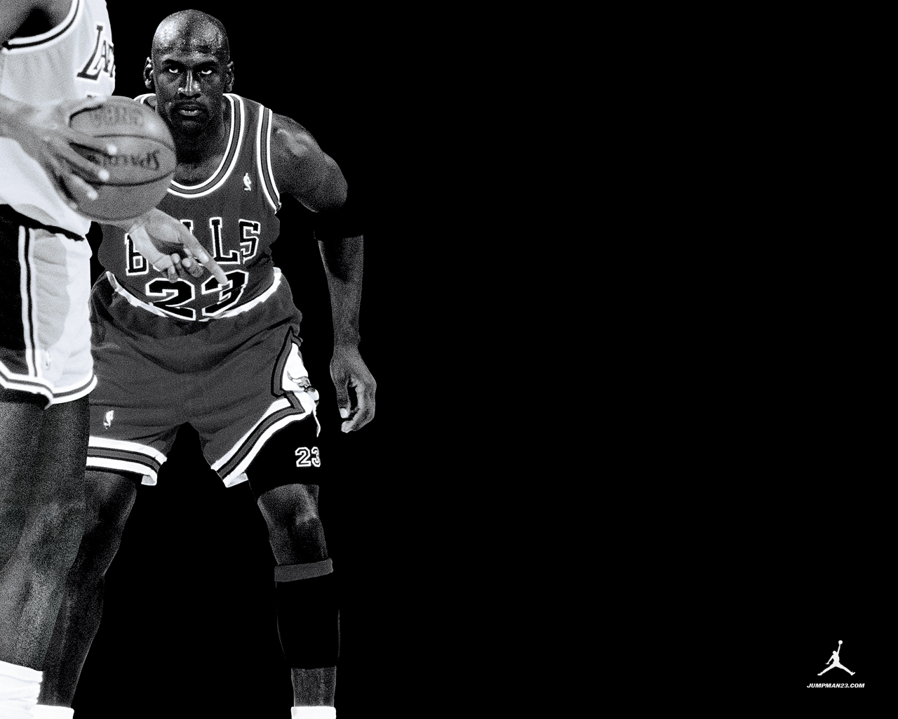 Black and white action shot of Michael Jordan dribbling the ball in a Chicago Bulls game