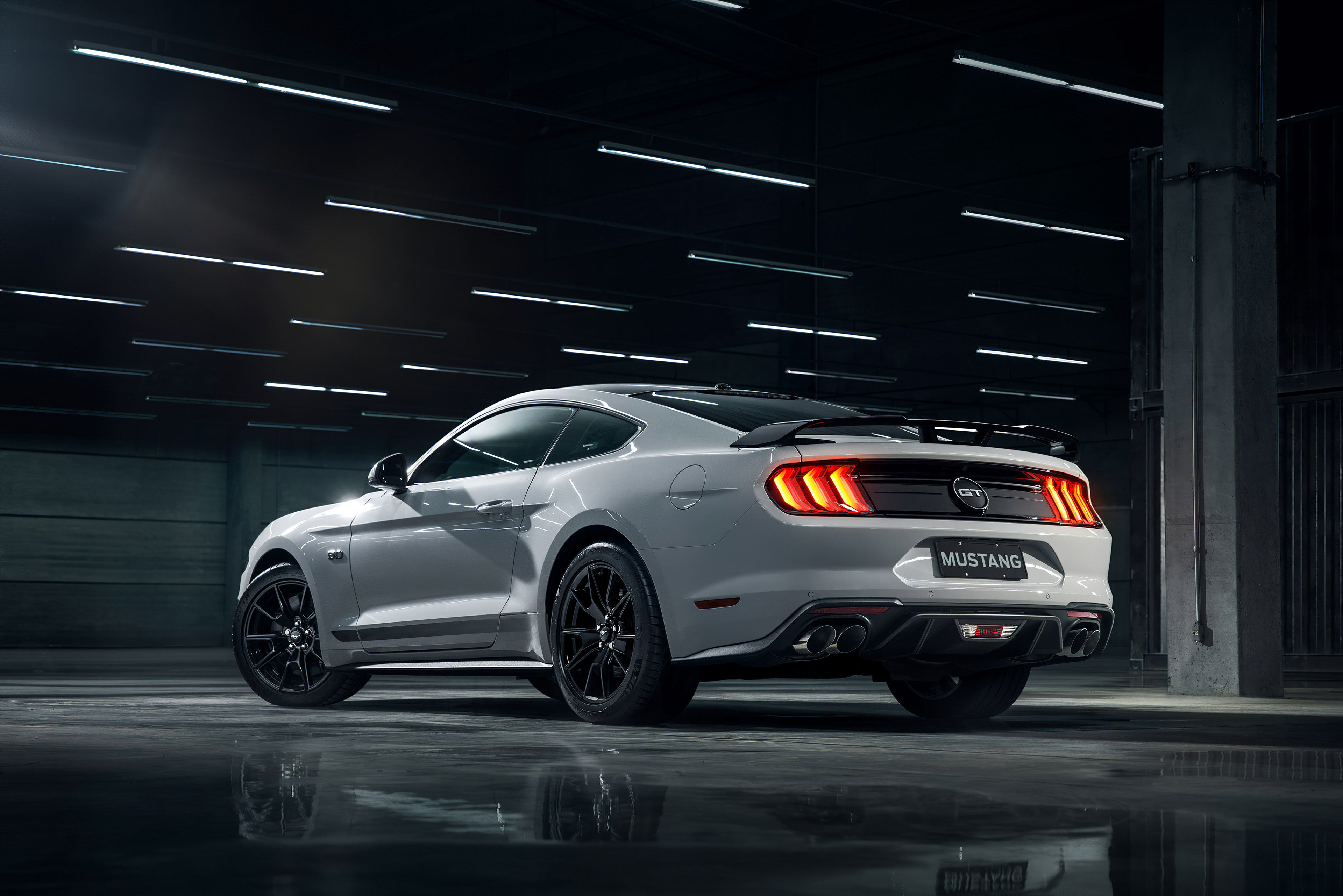 White Ford Mustang GT parked in a dimly lit garage