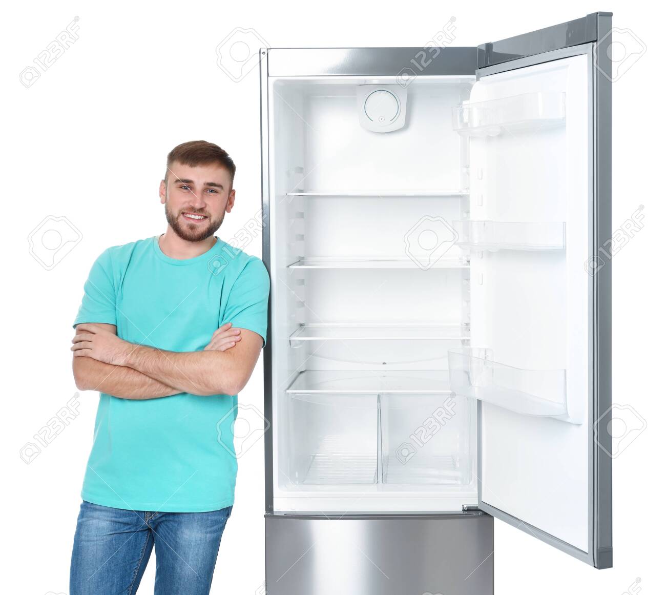Young Man Near Empty Refrigerator On White Background Stock Photo