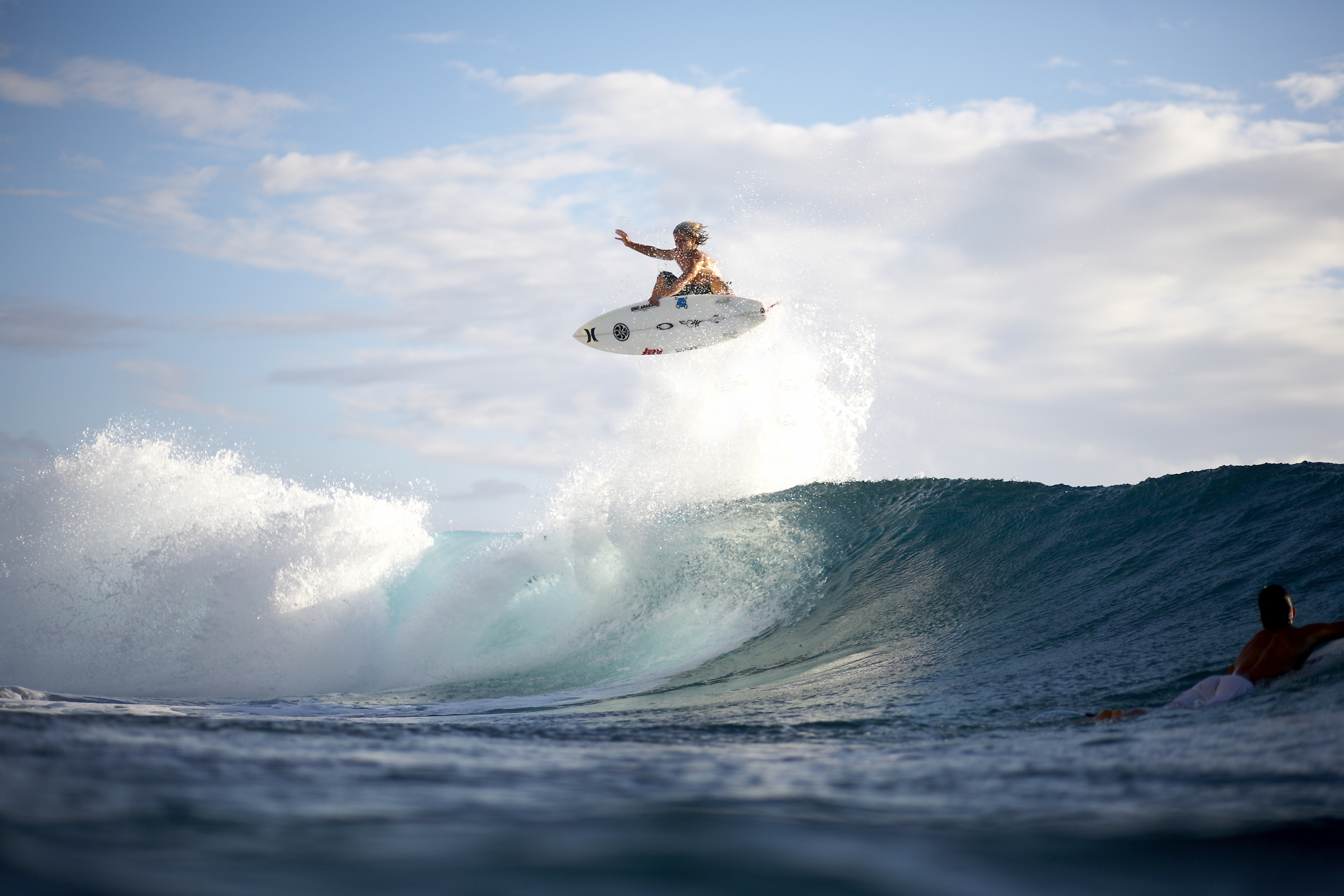 A surfer executes an aerial maneuver on a wave, showcasing the thrill and skill of surfing