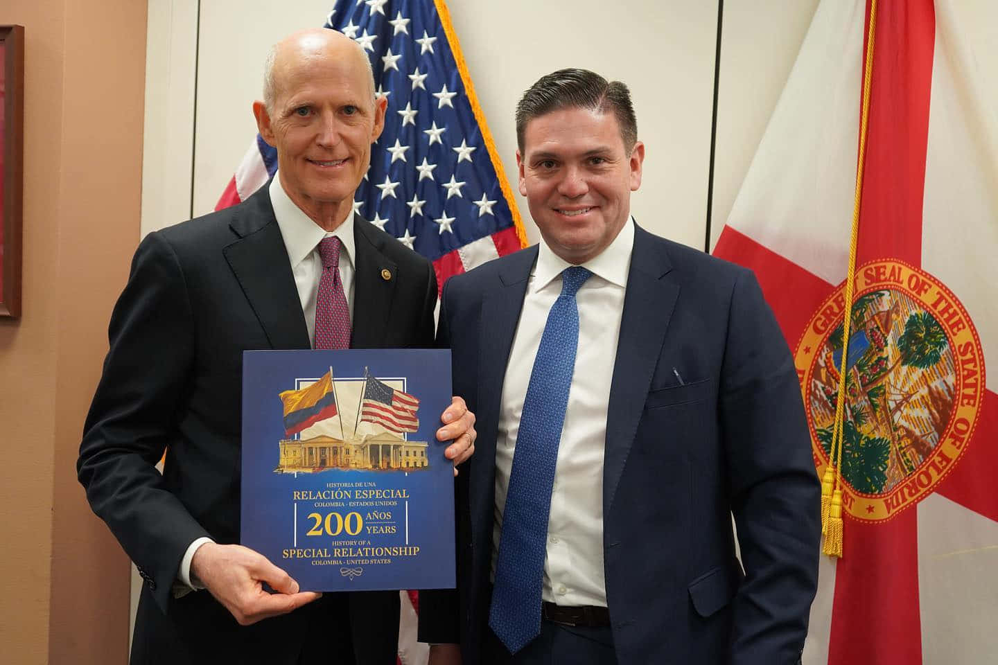 Rick Scott Holding Colombia Relations Commemoration Plaque 83mty38fqj4ode6s Wallpaper