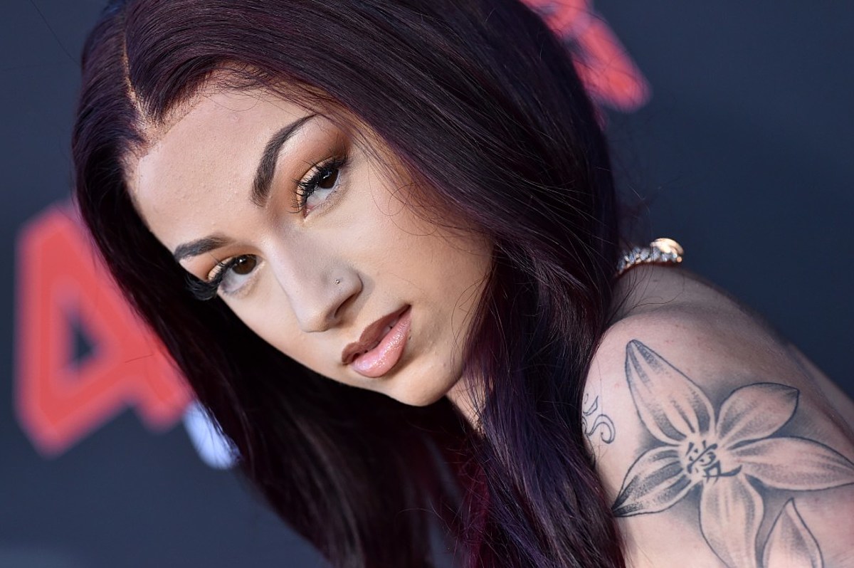 Close-up of Bhad Bhabie, highlighting her distinctive dark hair, subtle makeup, and a floral tattoo on her shoulder