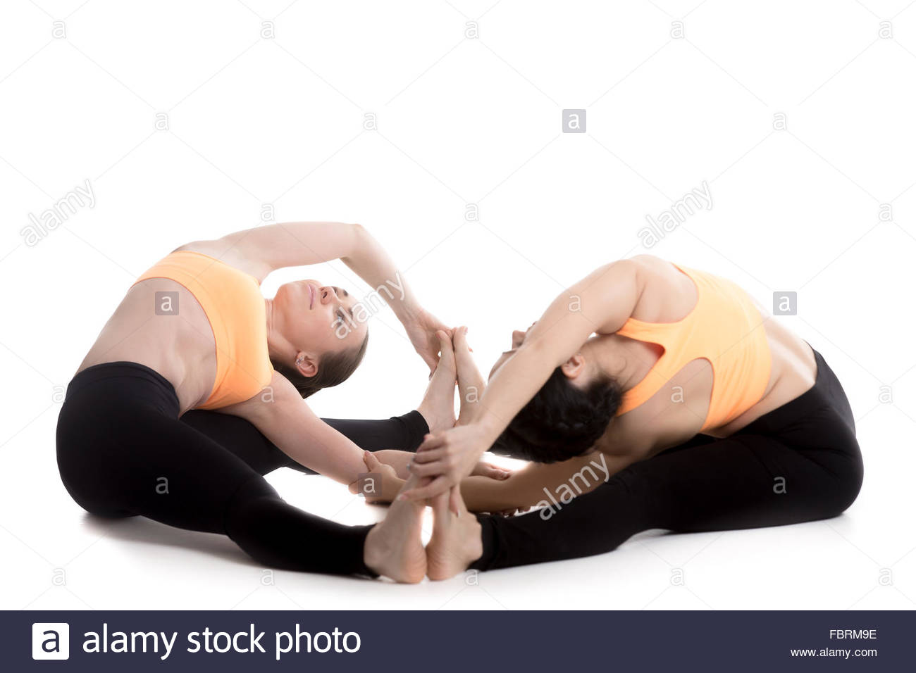 Two Sporty Girls In Orange Sportswear On White Background Doing