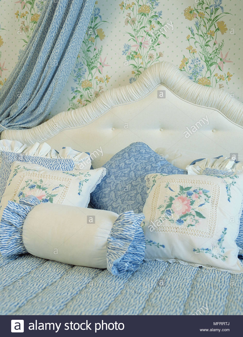 Bed Detail With Pillows Upholstered Headboard And Floral Wallpaper