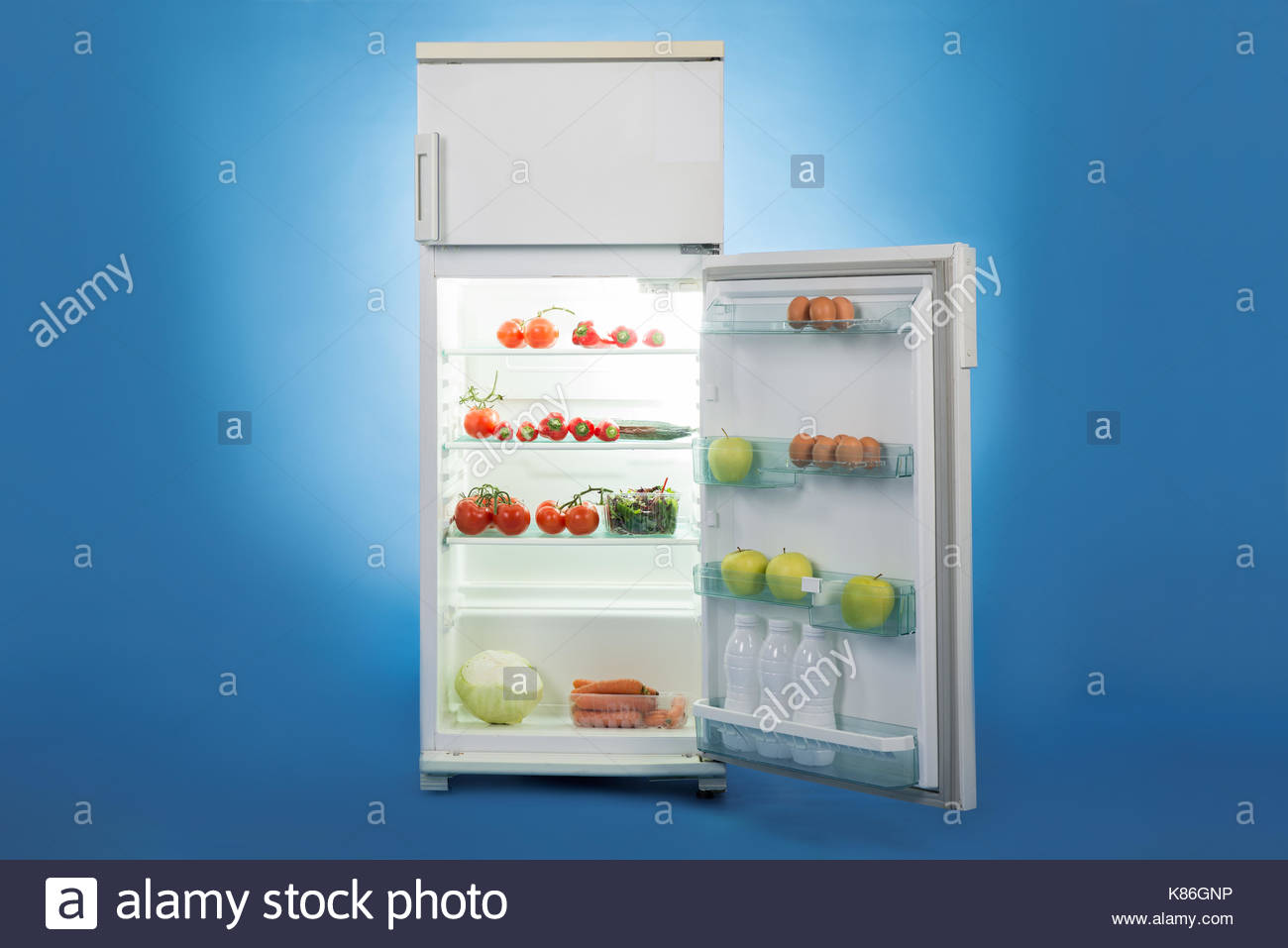 Open Refrigerator Full Of Healthy Food Isolated Over Blue