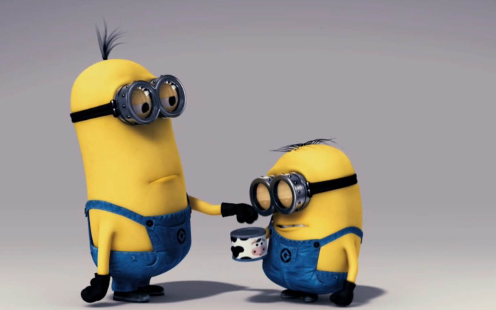 Two Minions from Despicable Me, one offering a small can to the other