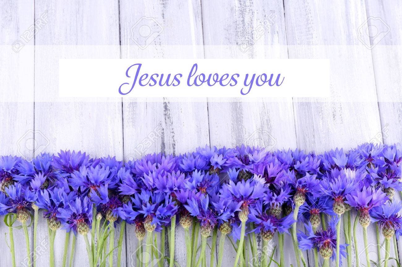 Beautiful Cornflowers And Text Jesus Loves You On Wooden