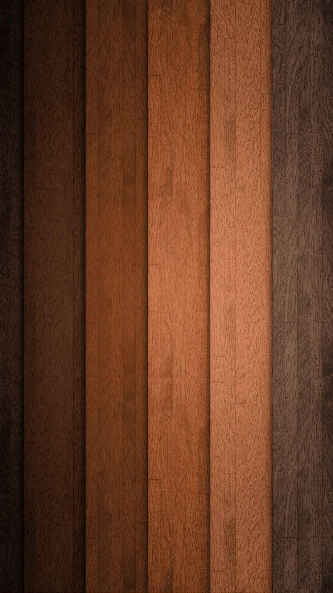 Vertical planks of brown wood, varying in shades from dark chocolate to rich caramel, create a textured and warm wallpaper background