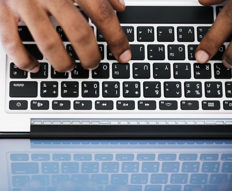 Person Typing On White And Black Laptop Puter Stock
