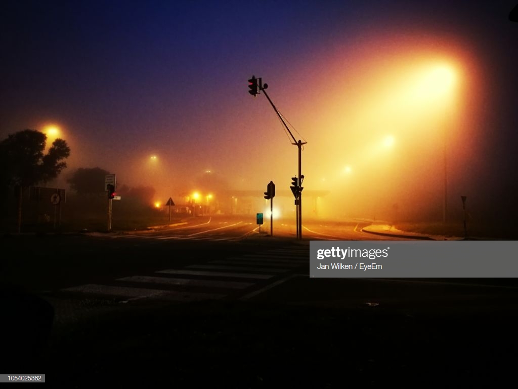Stoplight On Road Against Sky At Night High Res Stock Photo