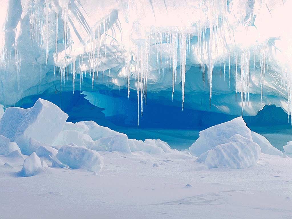 A breathtaking ice cave with glistening blue interior and delicate icicles
