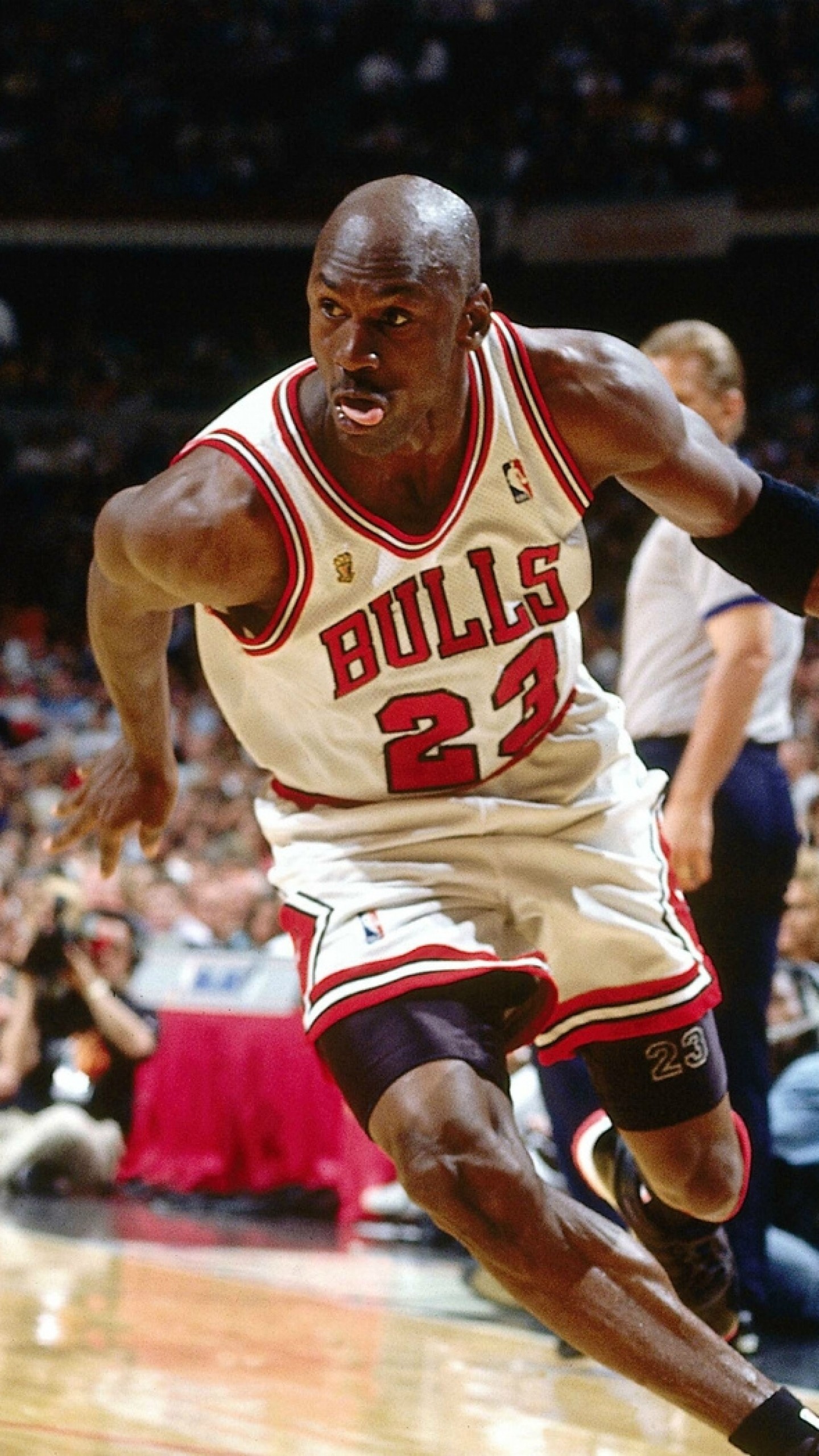 Michael Jordan dribbling the ball in a Chicago Bulls game, wearing his iconic number 23 jersey