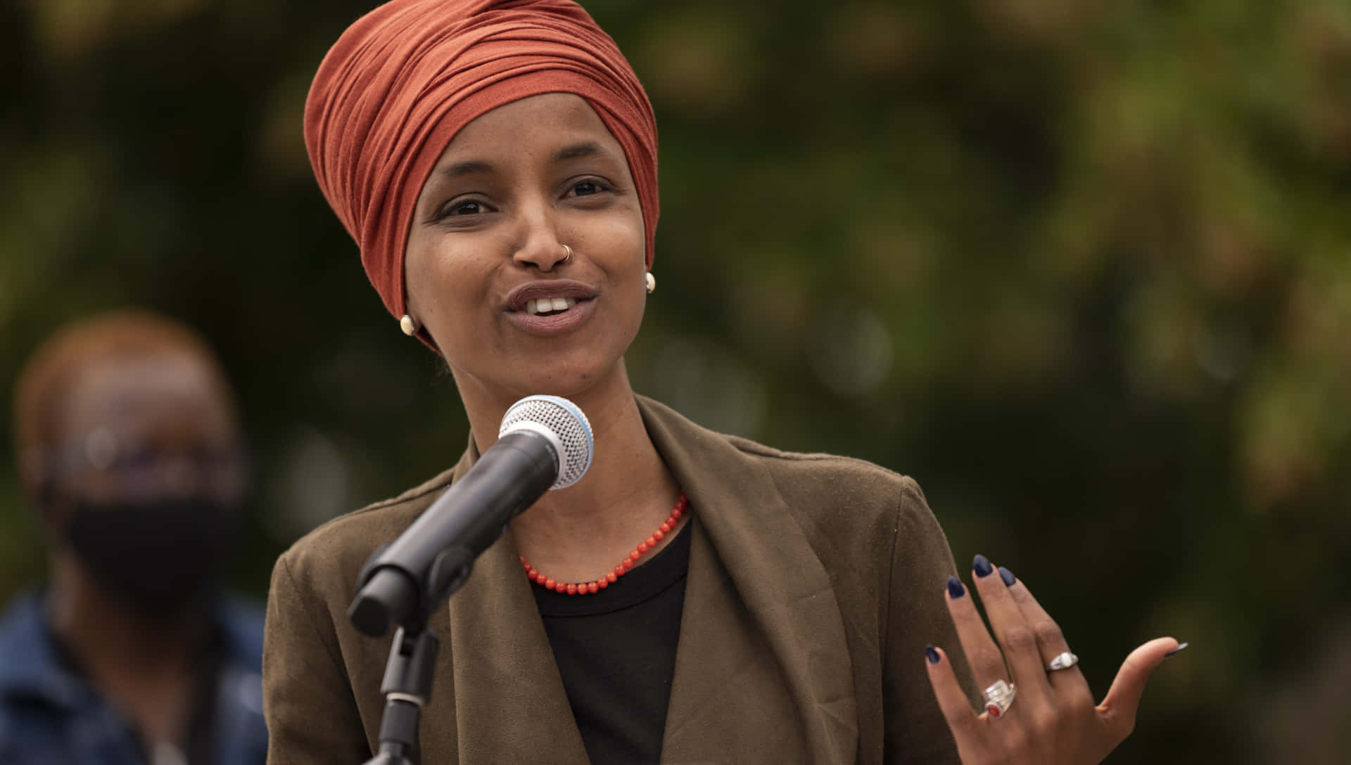 Congresswoman Ilhan Omar Posing With Pearl Earrings Wallpaper