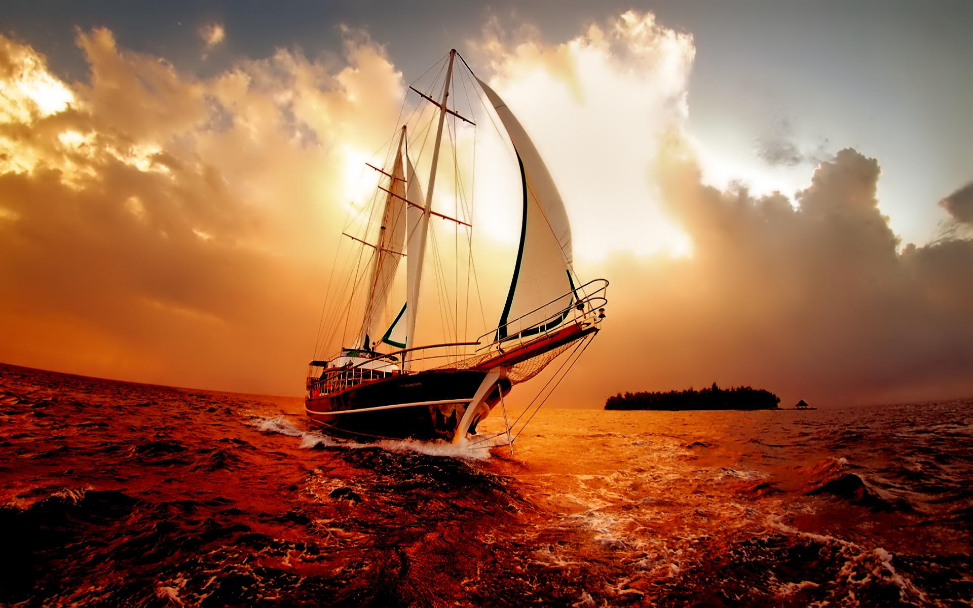 A majestic sailboat cruises through the ocean at sunset, its sails billowing in the wind, creating a stunning wallpaper