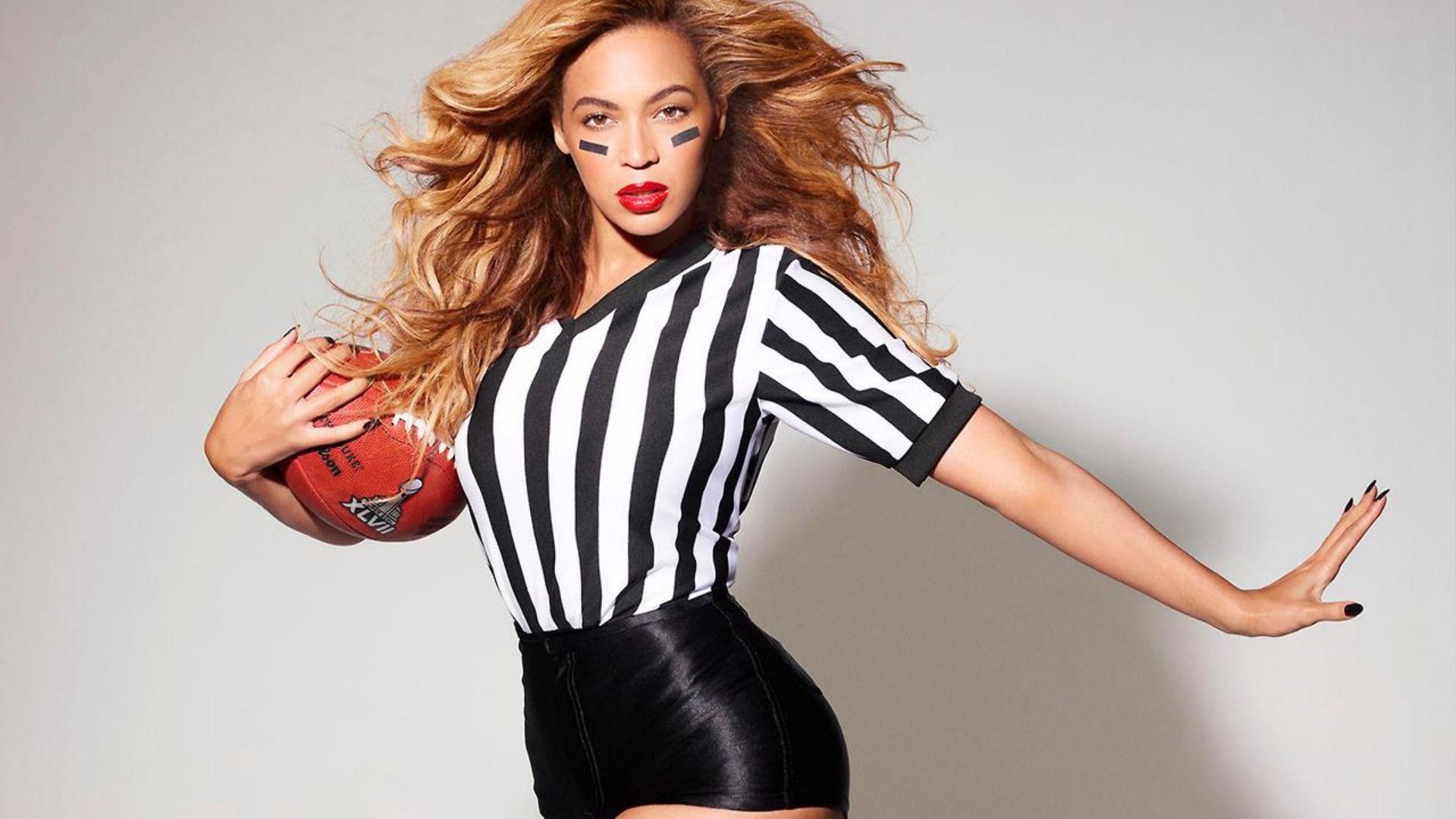 Beyoncé dressed as a football referee, holding a football and signaling a play