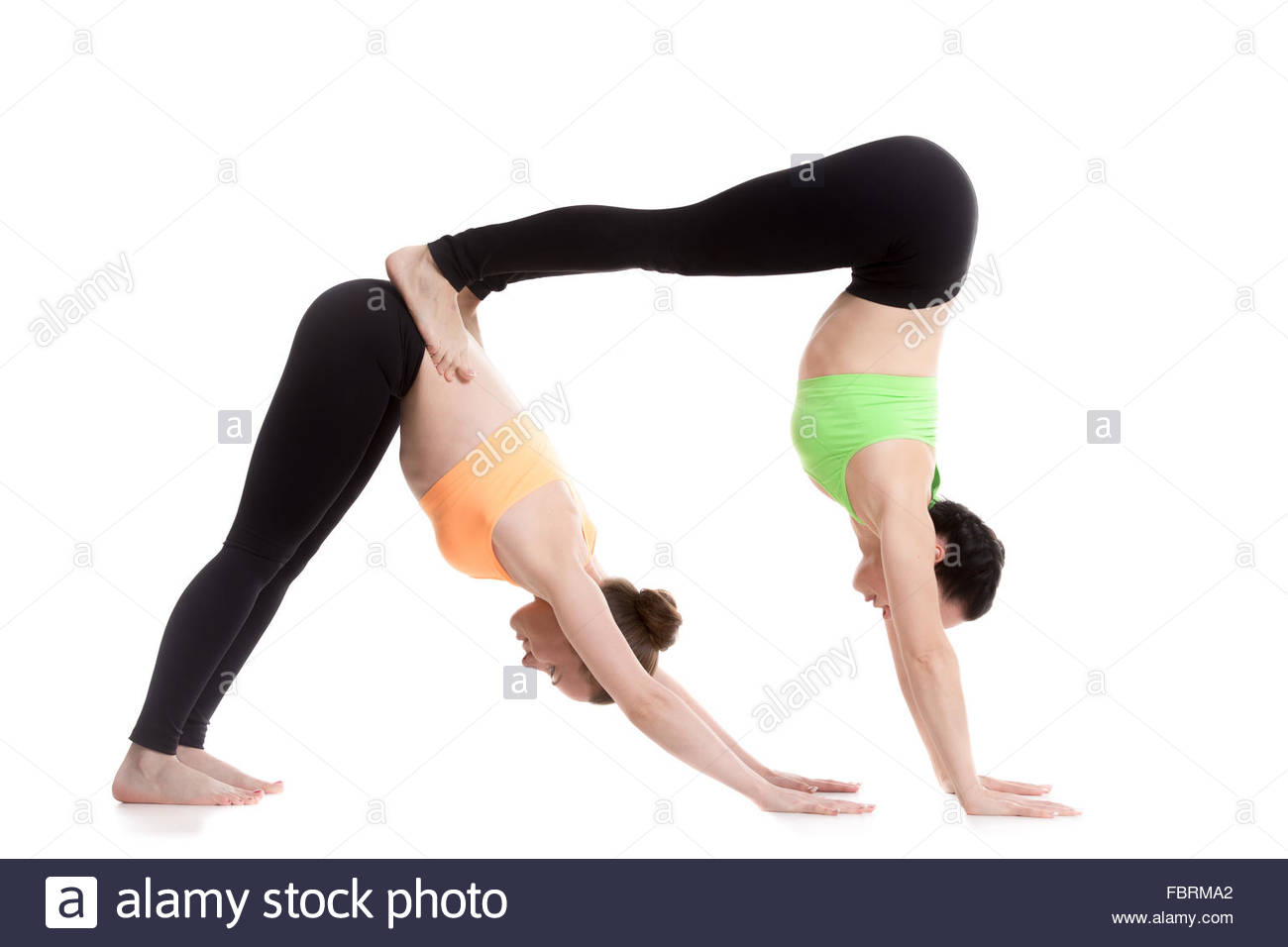 Two Sporty Girl On White Background Doing Acroyoga Yoga With
