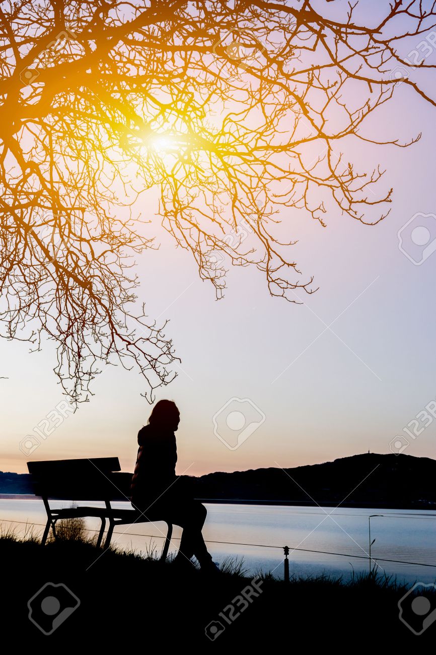 Sad Woman Silhouette Worried On The Beach At Sunset With