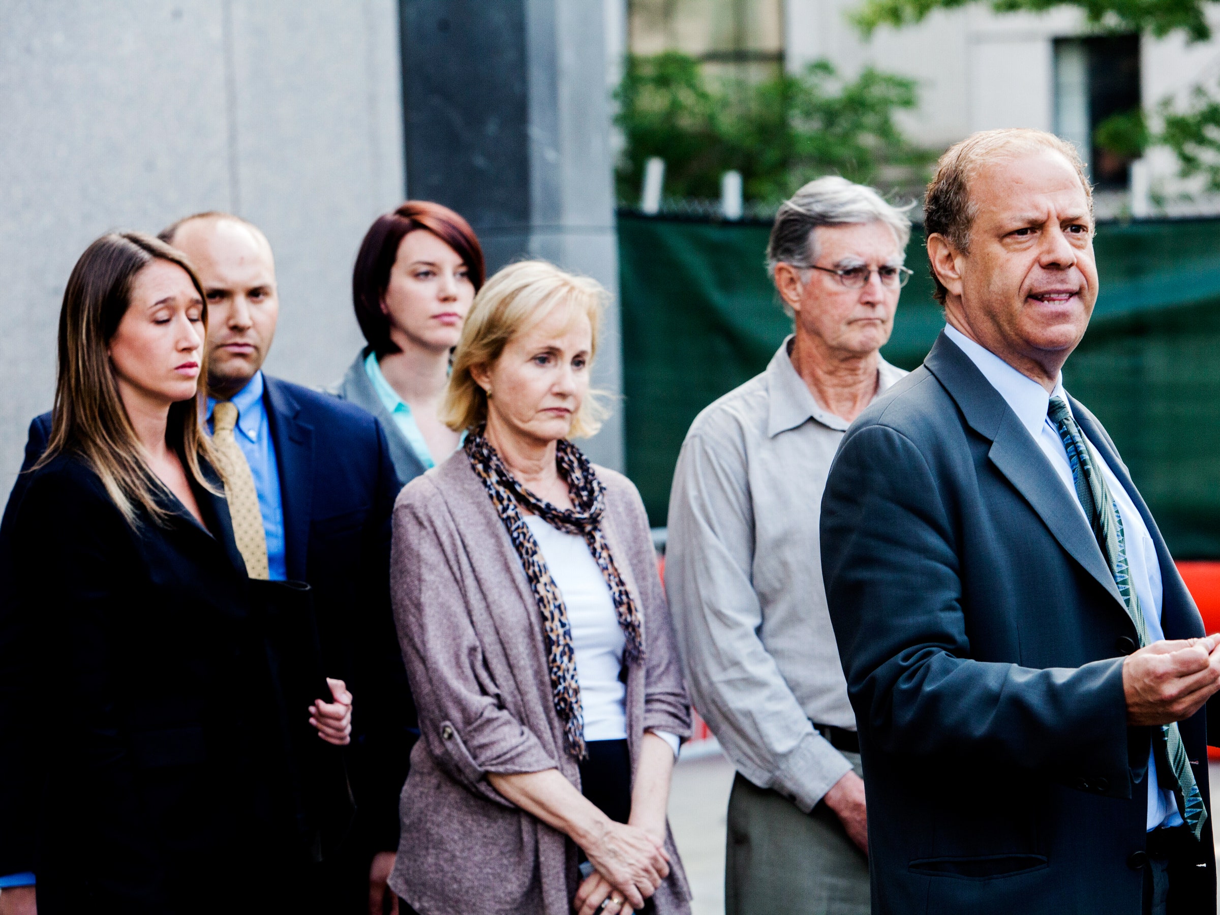 A group of people standing together, possibly at a press conference or similar event