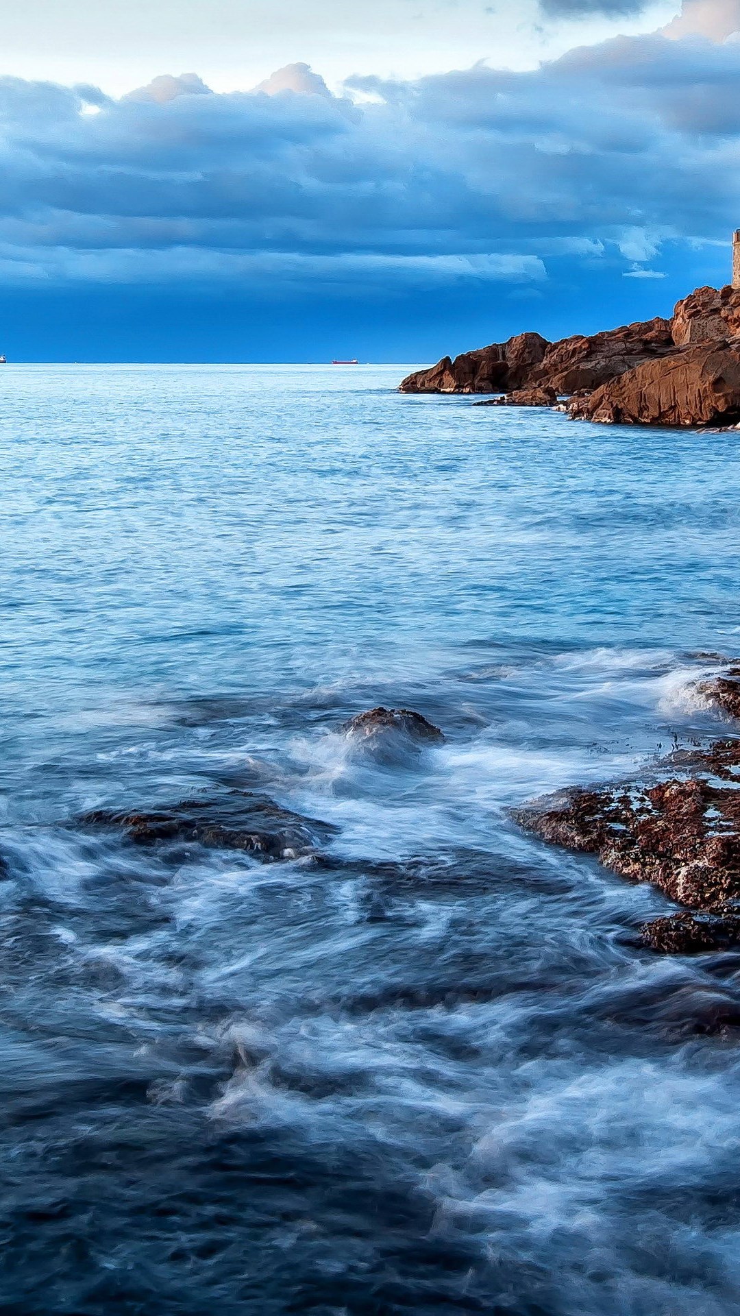 Stunning ocean view with rocky coastline and dramatic sky, perfect for a phone wallpaper