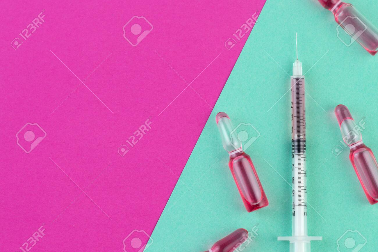 Ampoule And Syringe With Red Liquid On Colorful Background Flu