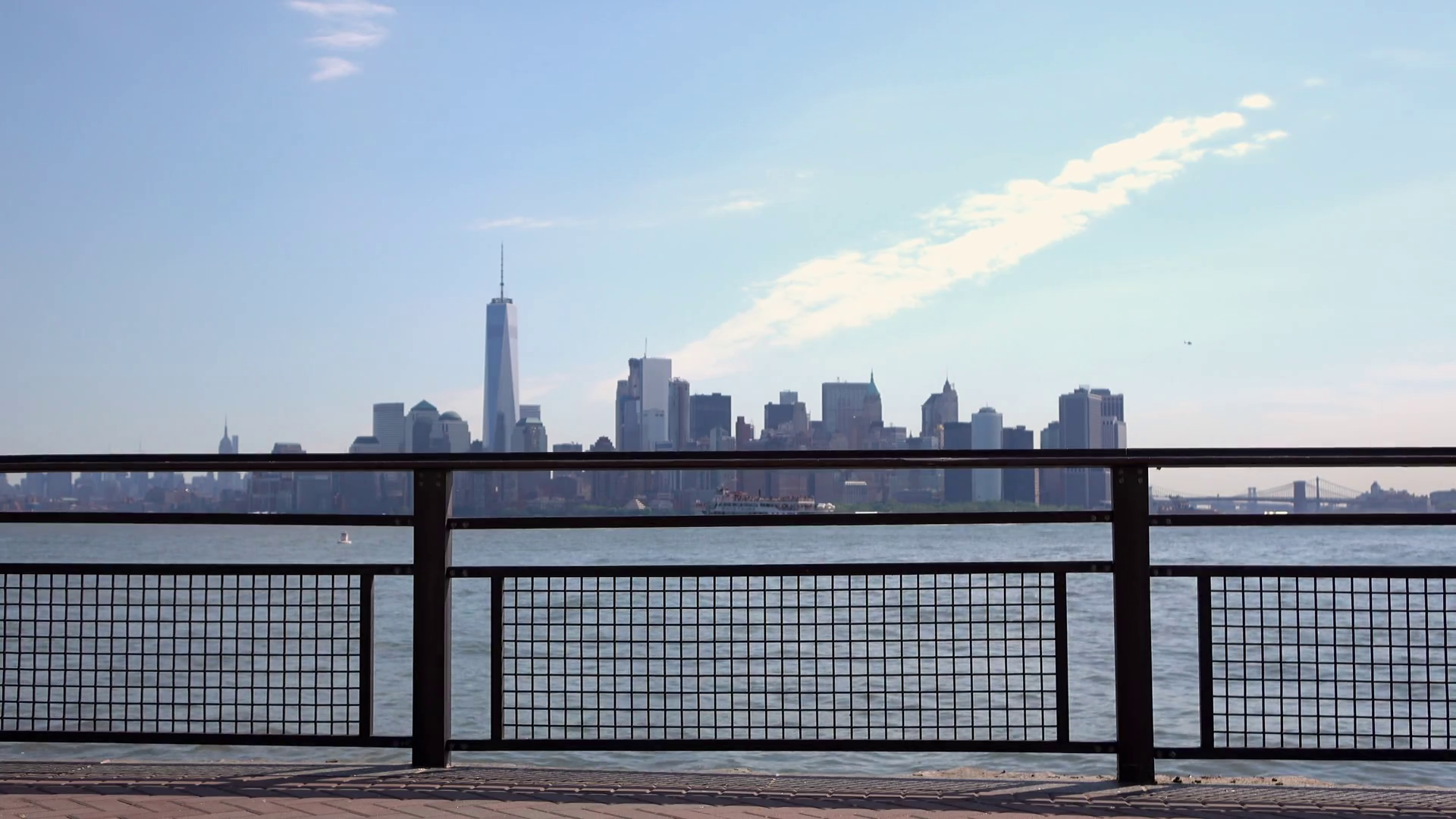 New York City In Background With Focus On Fence Along Water Edge