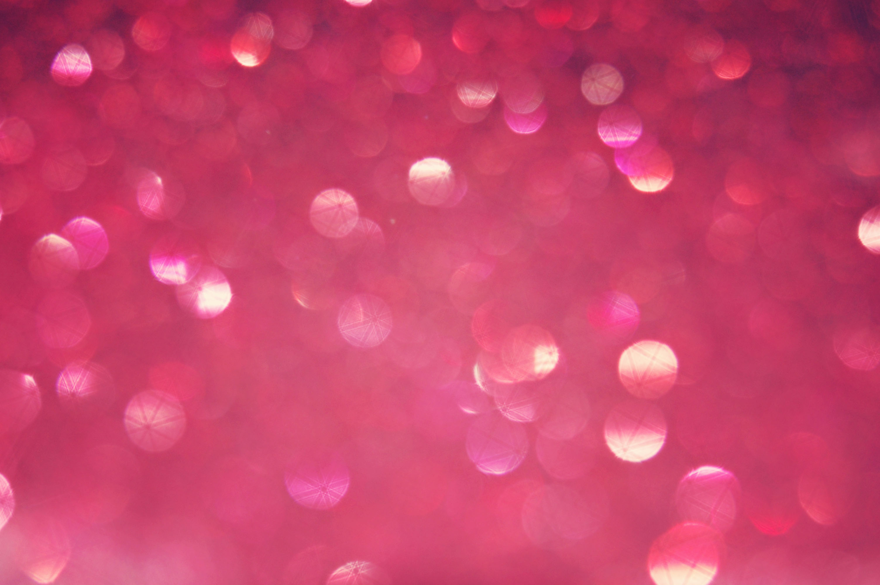 Abstract background of sparkling pink glitter with bokeh effect, perfect for a glamorous and feminine wallpaper