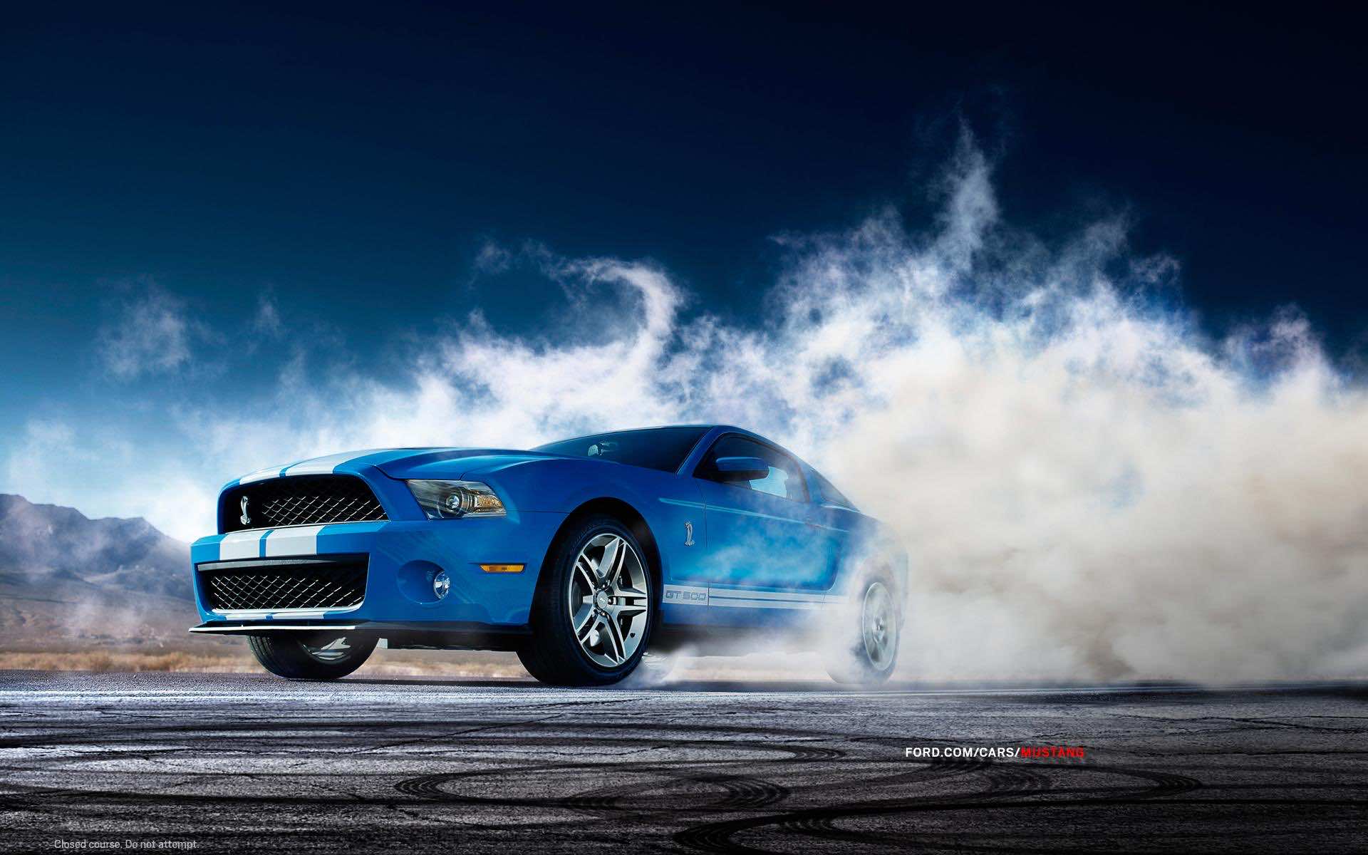 Blue Ford Mustang Shelby GT500 burning rubber on a desert road