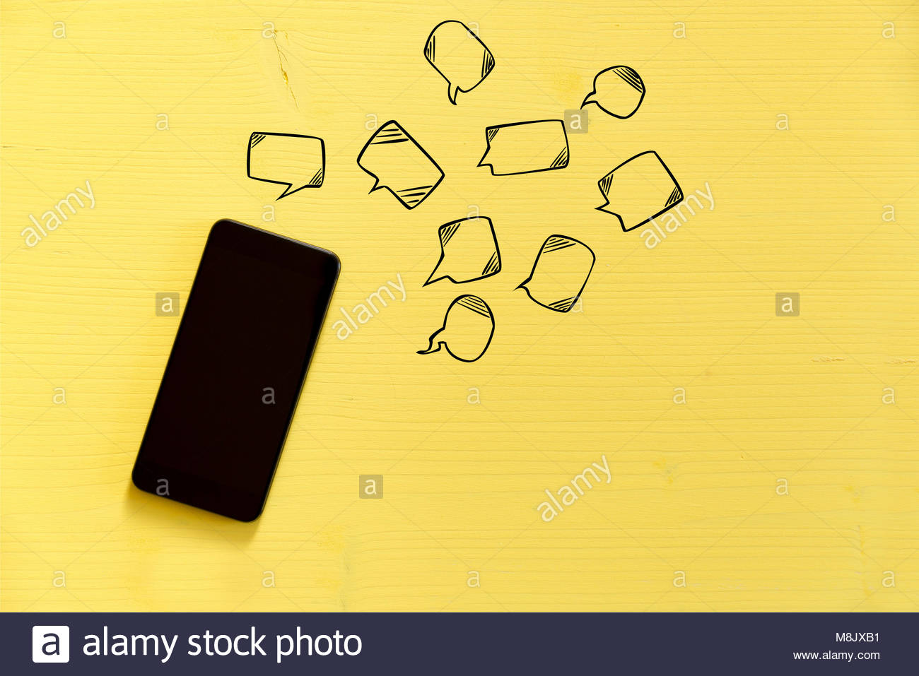 Smartphone On Yellow Background With Text Bubbles Around