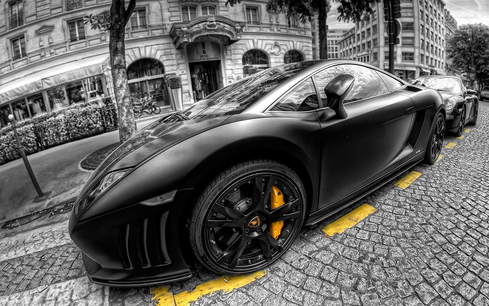 Black Lamborghini Gallardo parked on a cobblestone street in front of a classic building