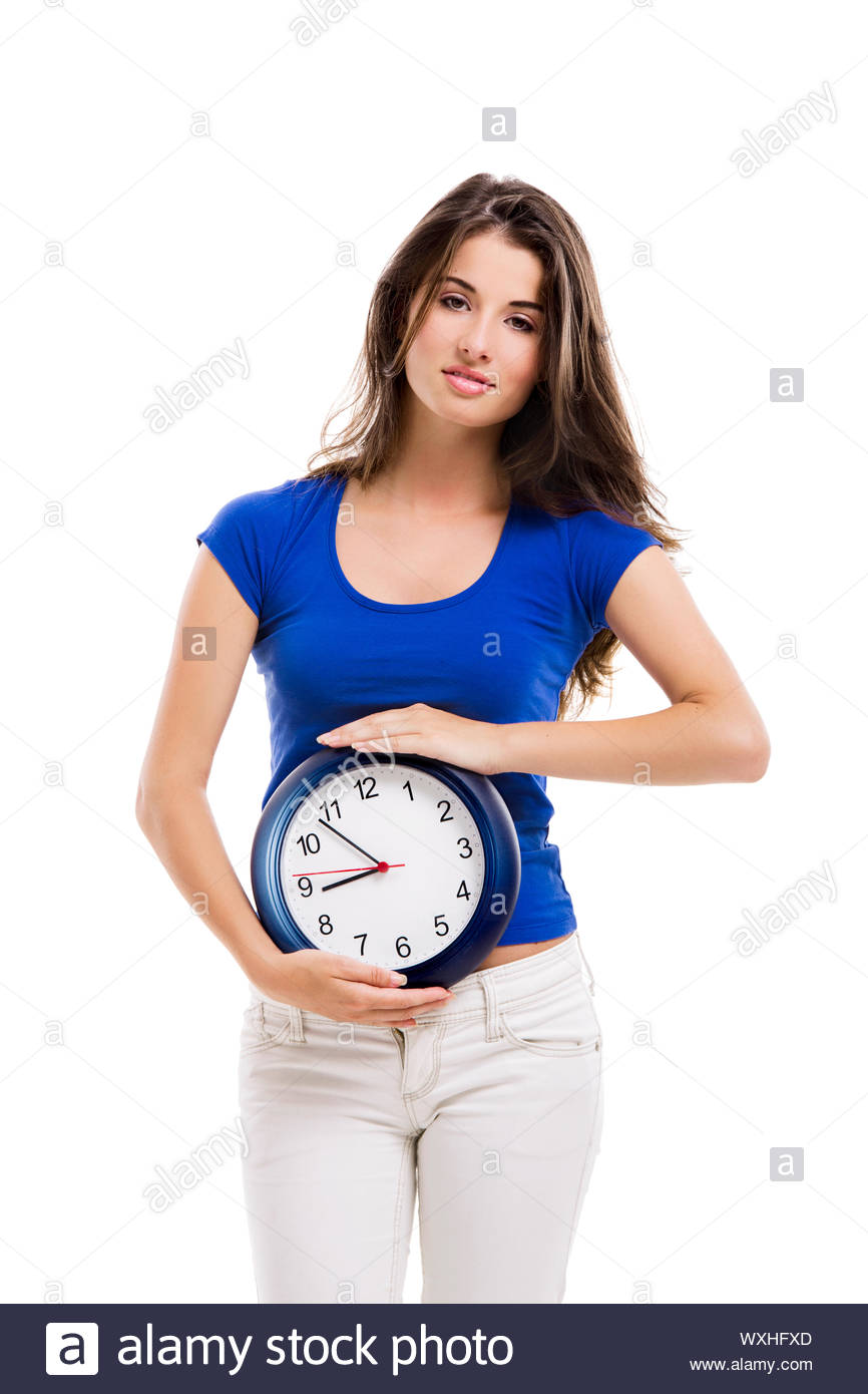Causal Young Woman Holding A Clock Isolated Over White