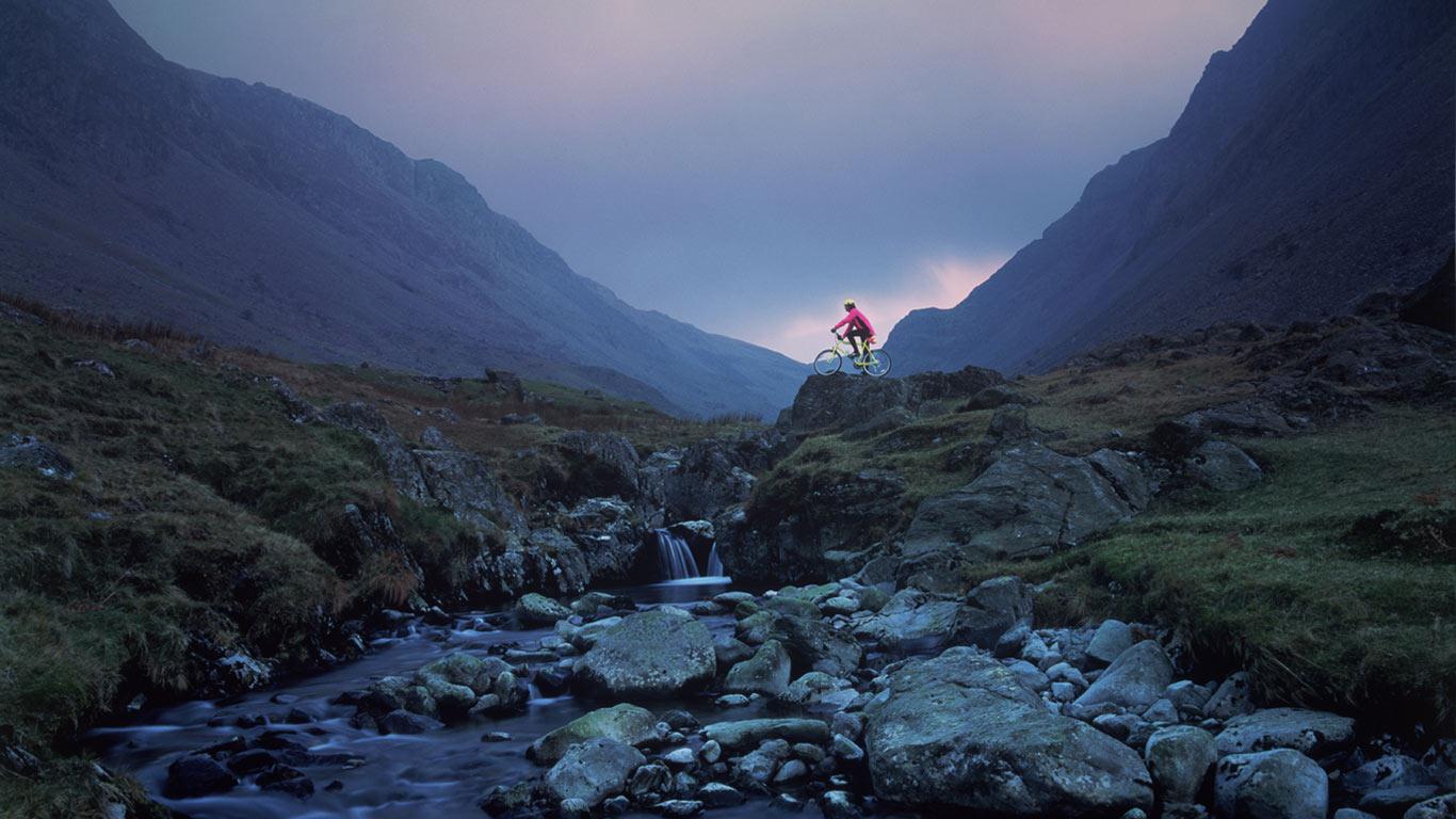 The Great Lakes   Cyclist on mountain bike Honister Pass The Lake