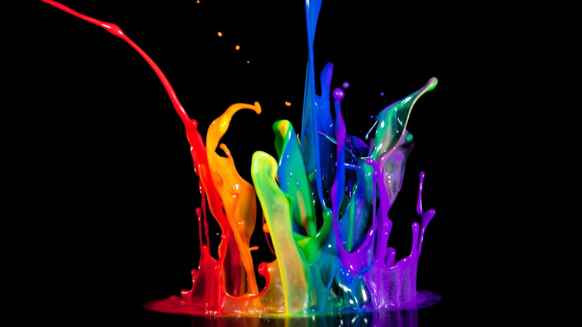 Rainbow Paint Splashing On A Black Wallpaper