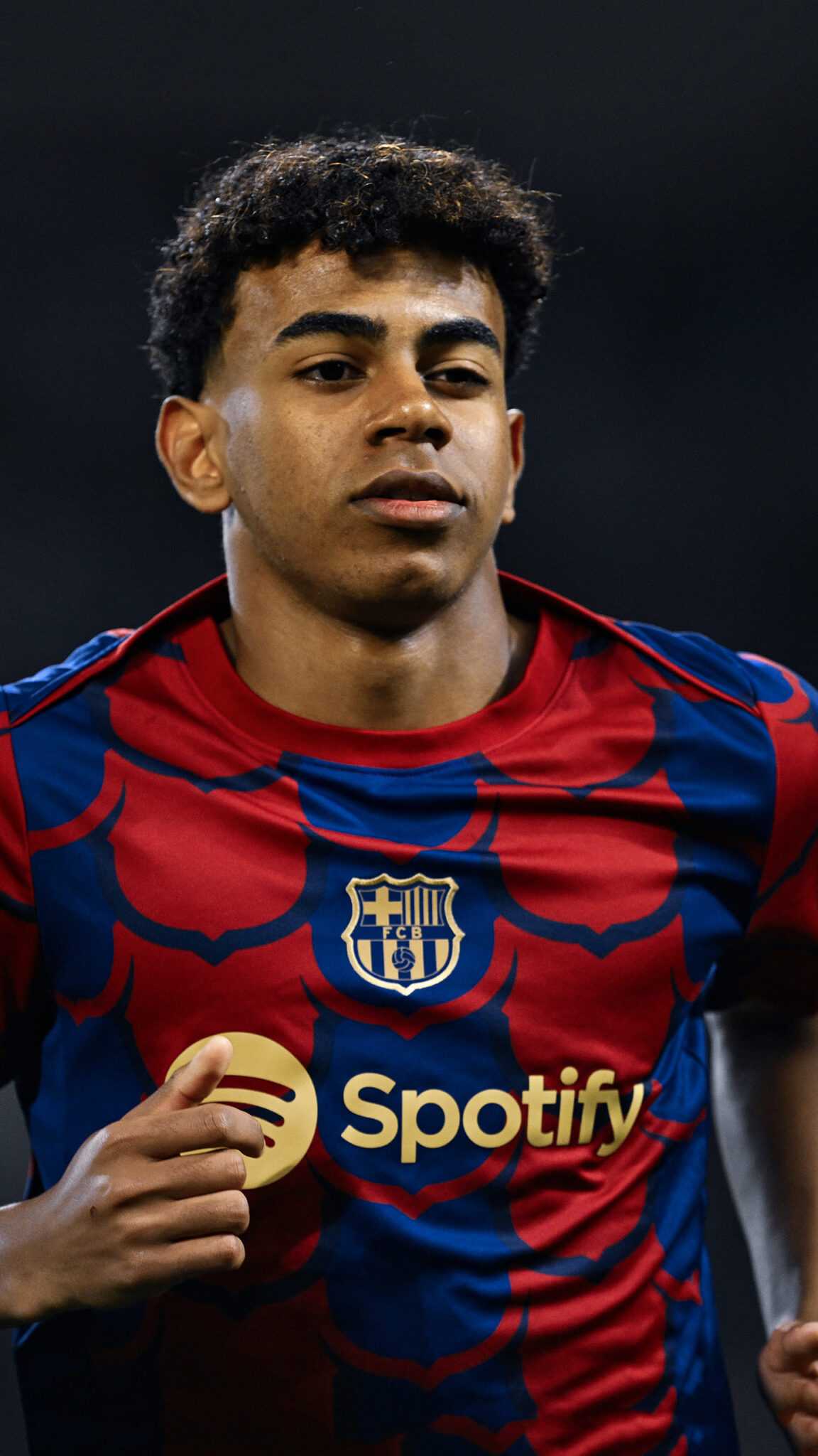 Lamine Yamal of FC Barcelona in action during a match. He wears the team's red and blue jersey with the Spotify logo