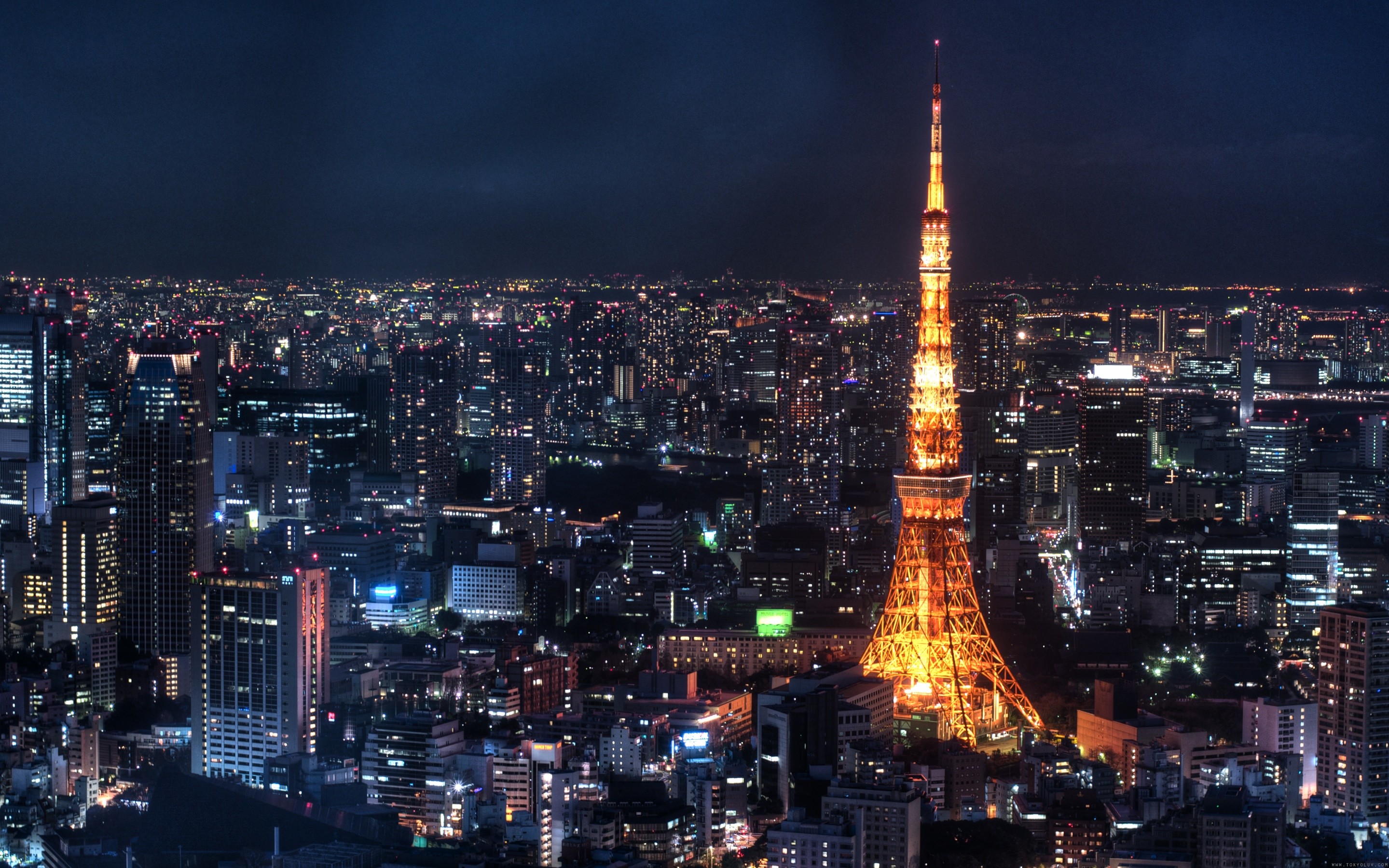 Tokyo Tower at night, illuminated against the dark cityscape
