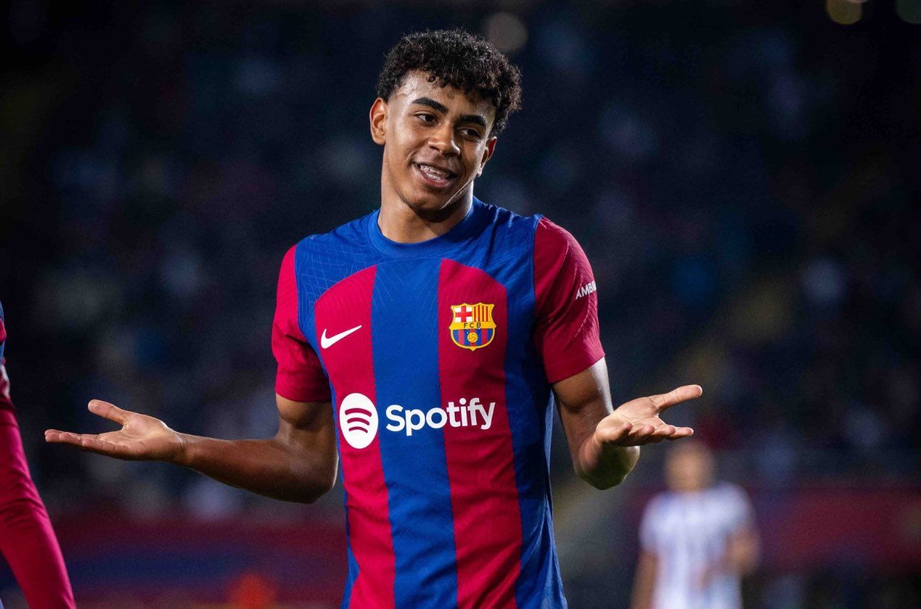 Lamine Yamal of FC Barcelona in action during a match. He is wearing the team's home kit and has a questioning expression on his face