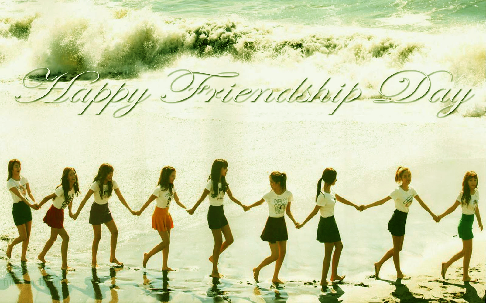 A group of friends holding hands and walking along a beach, celebrating Friendship Day