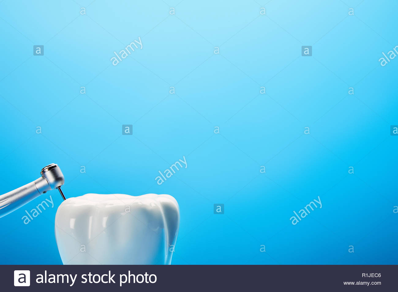 Close Up Of Dental Drill And White Tooth Model On Blue