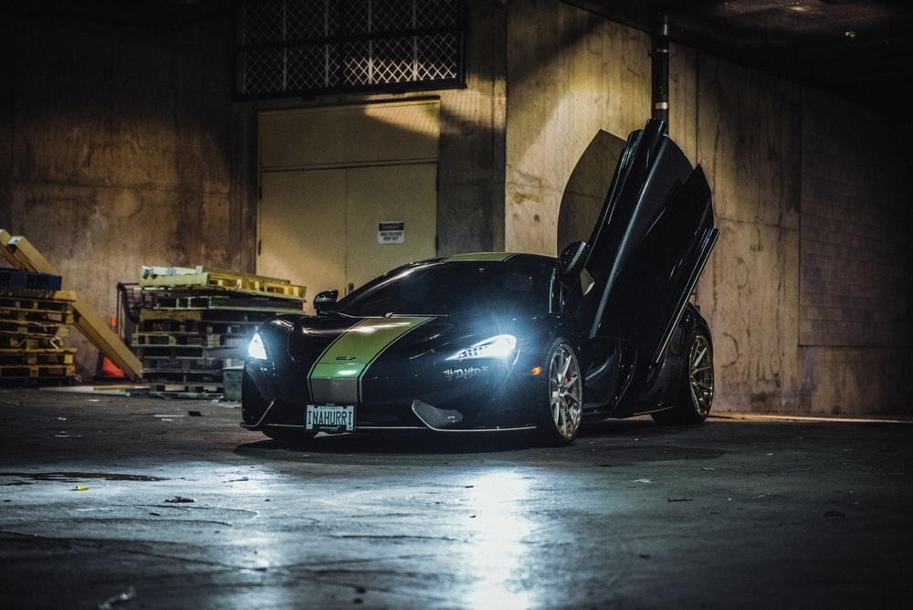 Black Sports Car With Open Door Parking Near Building Photo